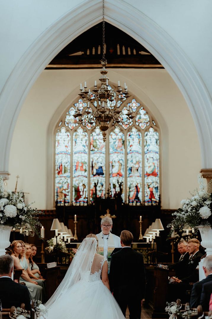 The bride and groom kneel for their traifitonal Christian church ceremony 