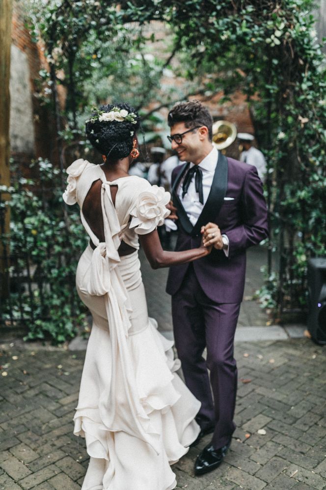 Bride in a preloved fitted wedding dress with ruffle shirt and sleeves and ribbon tie up back detail 