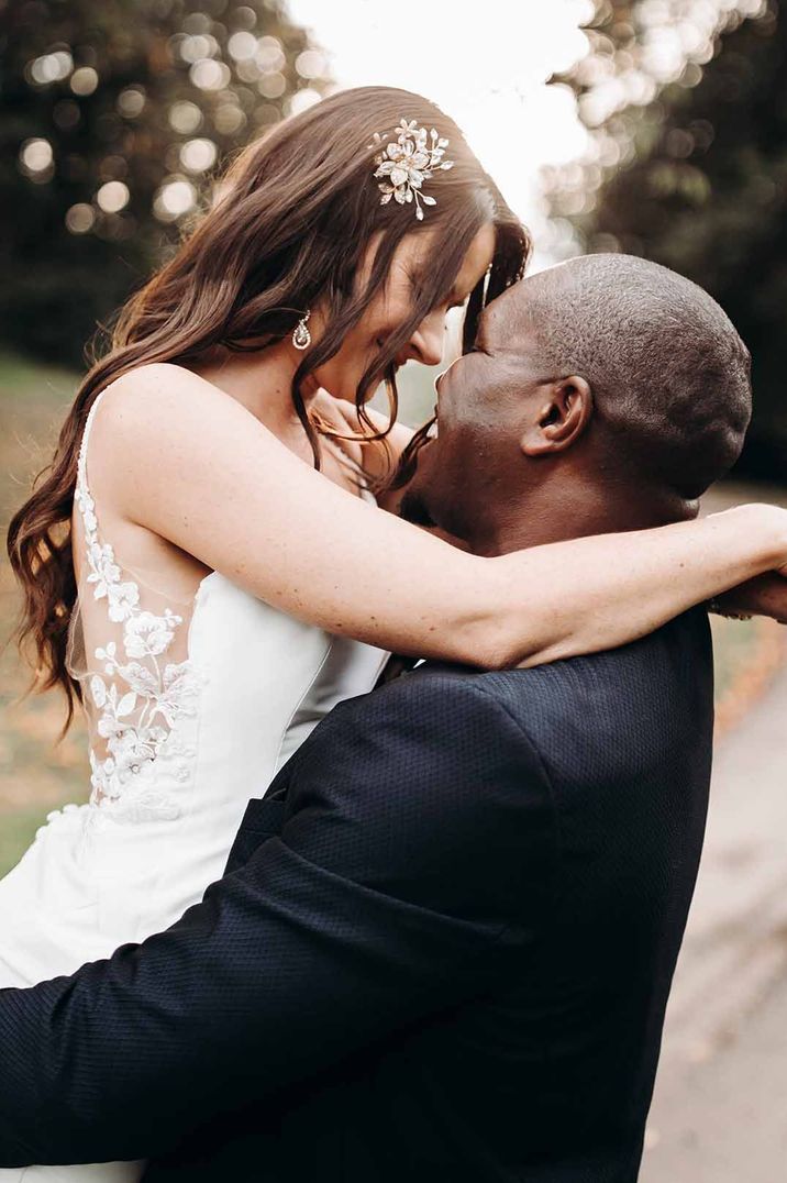 Bride wears pearl drop diamanté earrings with lace illusion back wedding dress