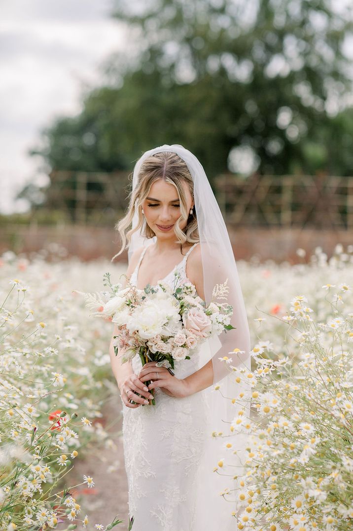 Bride carrying a white and light pink bouquet with roses 