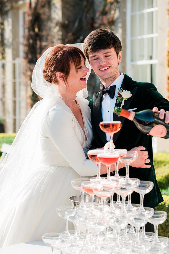 Bridgerton wedding venue with bride and groom pouring champagne for their champagne tower 