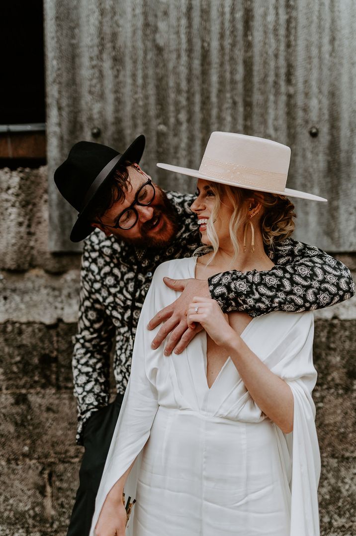 Stylish bride and groom wearing hats for their wedding under 5k 