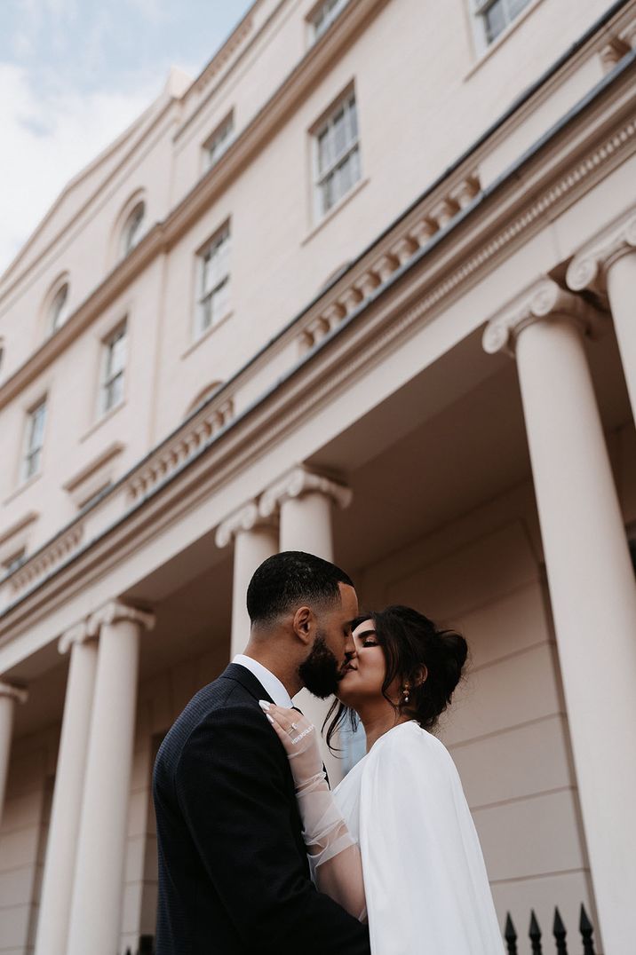 Bride wears personalised sheer gloves whilst kissing her groom