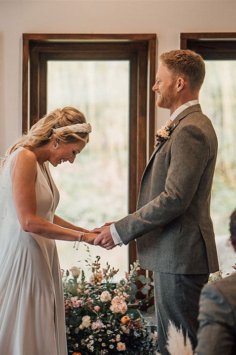 A stunning wedding ceremony for bride in pearl wedding veil with groom in light grey suit 