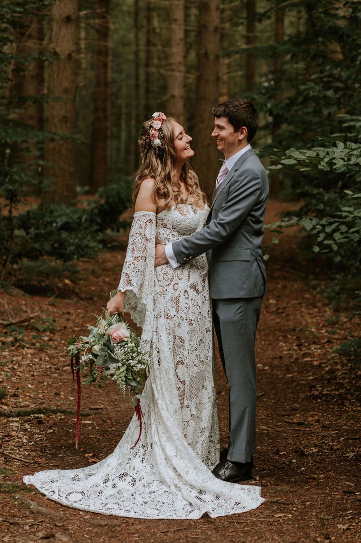 Bride in long bell sleeve lace medieval wedding dress with the groom at the woodland wedding 