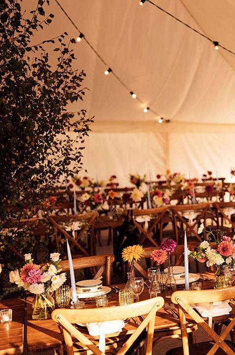 Outdoor marquee garden party wedding with bold colourful flower arrangements 