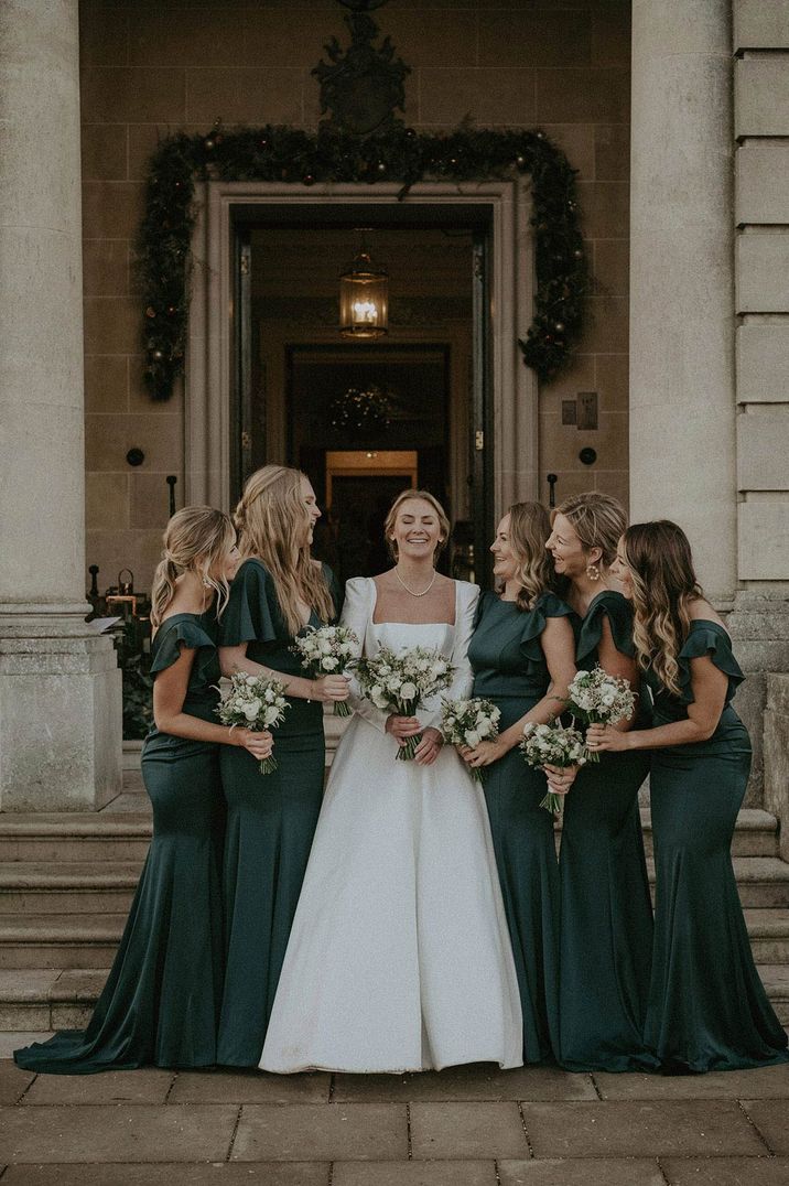 Bridal squad in bottle green bridesmaid dresses and square neck wedding dress