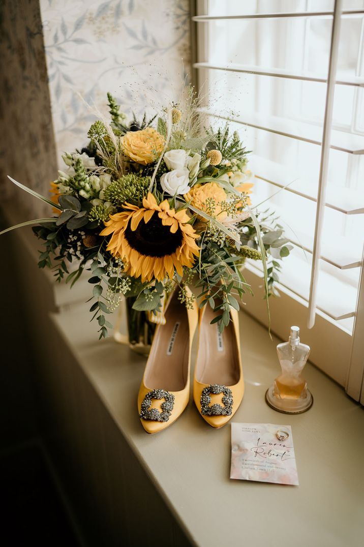 Jean Paul Gautier bridal perfume beside sunflowers and Manolo Blahnik yellow heels 