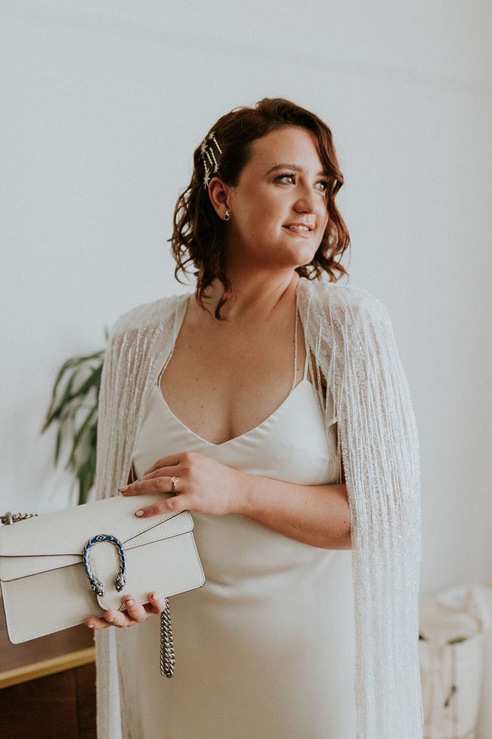 Bride wears glittering tasseled wedding cape 