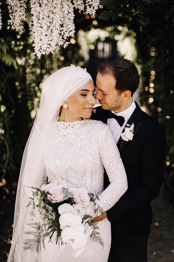 Muslim wedding with bride carrying a classic white orchid and pink rose bouquet 