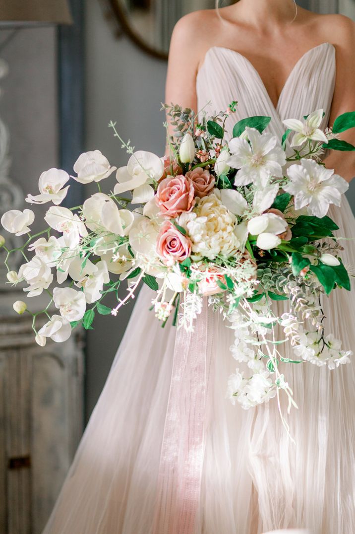 Pink and white oversized wedding bouquet carried by bride with orchids and roses 