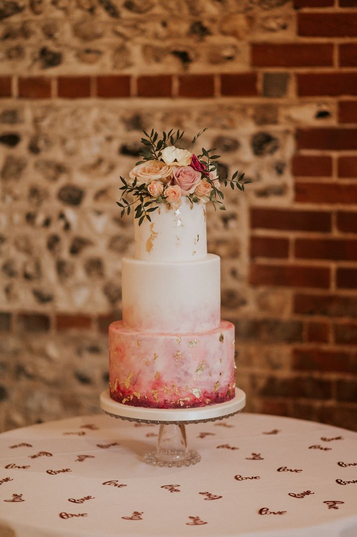 Ombre iced wedding cake with light pink flowers as decoration