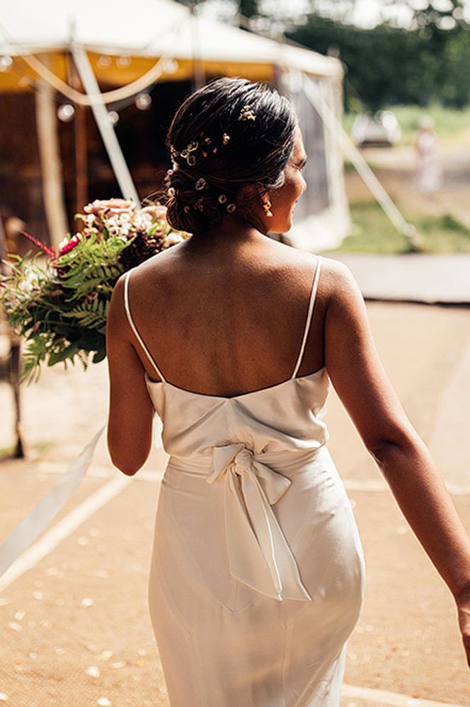 Bride in a satin slip wedding dress with thin straps and tie up ribbon back detail 