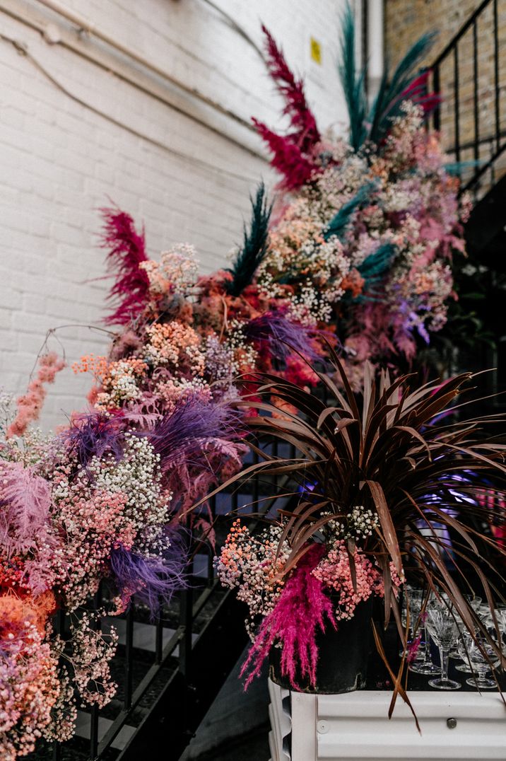 Coloured pampas grass staircase wedding floral arrangement 