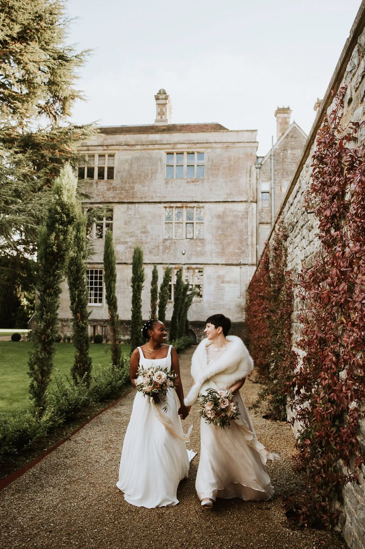 Elmore Court lesbian wedding with two brides in A line wedding dresses holding baby pink rose wedding bouquets 