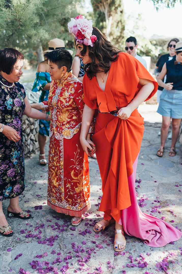 Newlyweds greeting guests wearing matching red at their LGBTQI+ wedding