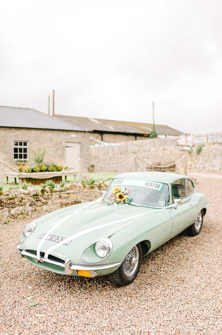 Mint green vintage car for wedding with sunflower decorations and white ribbon