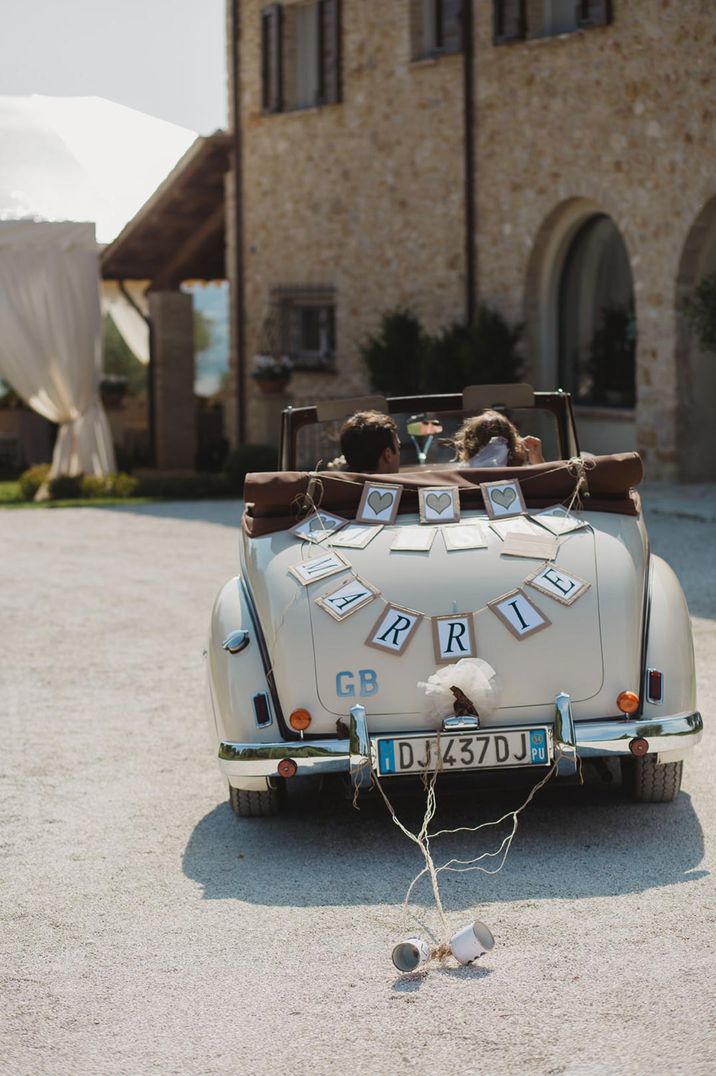 Convertible wedding car with cardboard and tin can decorations