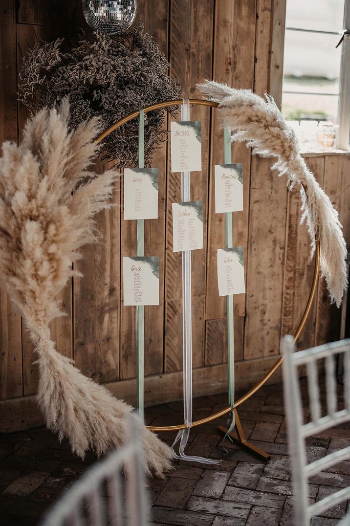 Boho metal hoop table plan with dried grass and mint green and white ribbon 