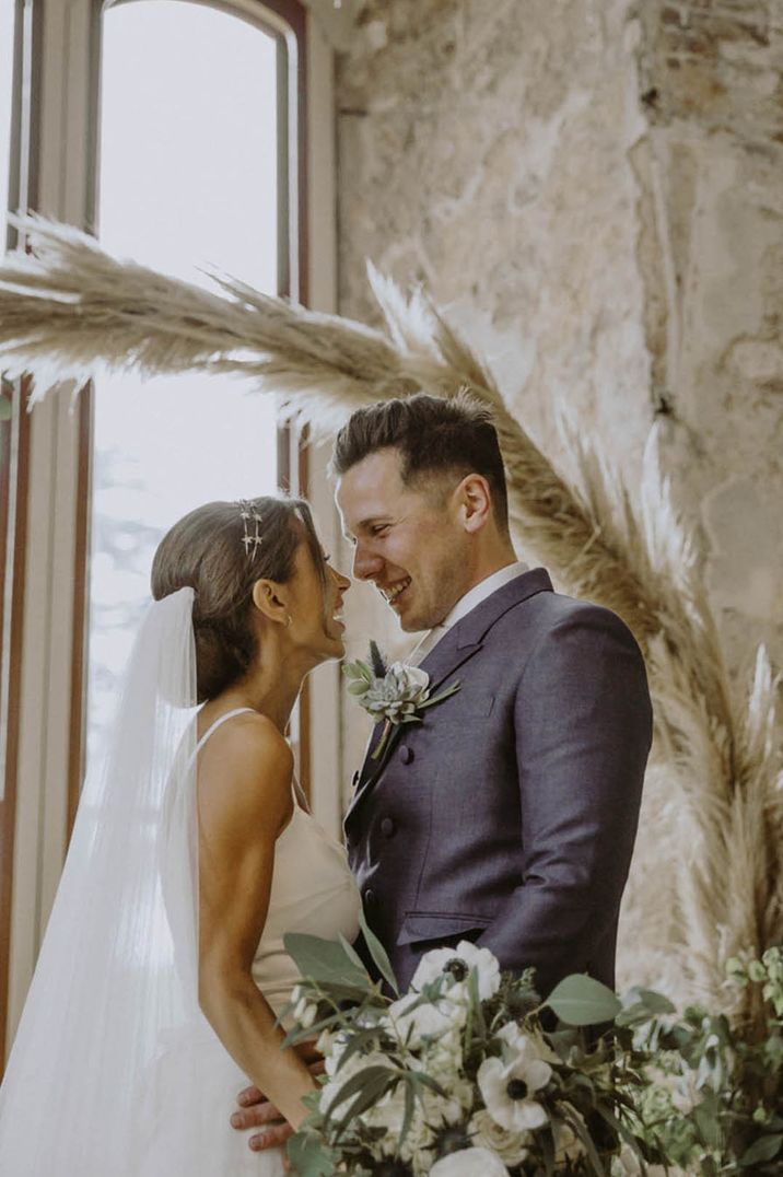 Lulworth Castle wedding with the bride and groom gazing into each other's eyes for a cute couple photo 