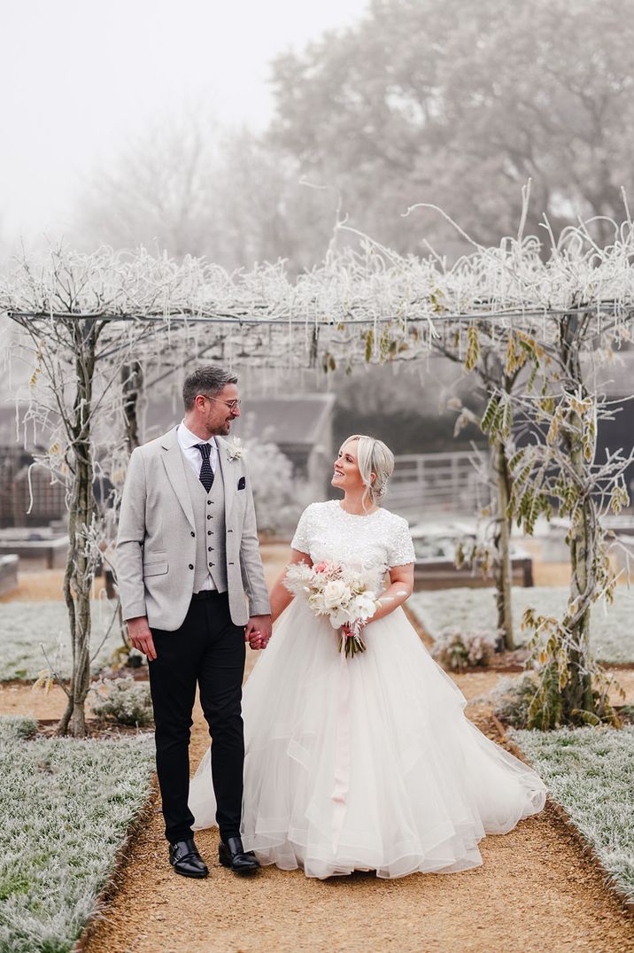 Light grey three piece suit with spotted tie with the bride in a short sleeve sequin top and princess tulle layered skirt 