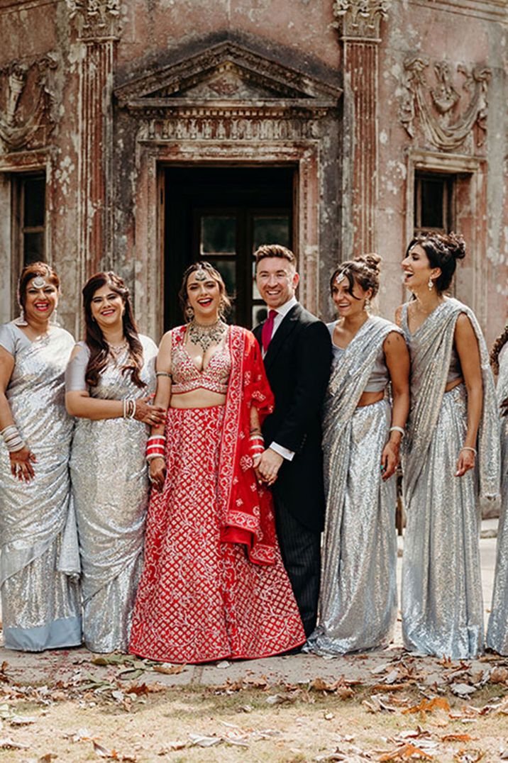 Silver metallic sari dresses for bridesmaids with the bride and groom at their outdoor summer wedding 