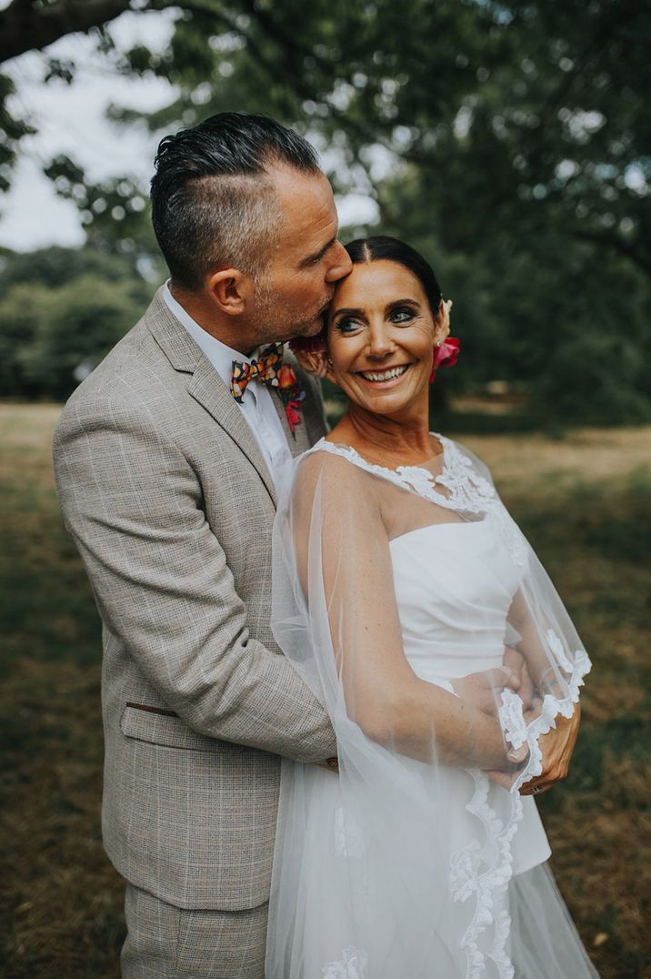 Groom embracing the bride for their couple portraits at colourful wedding 