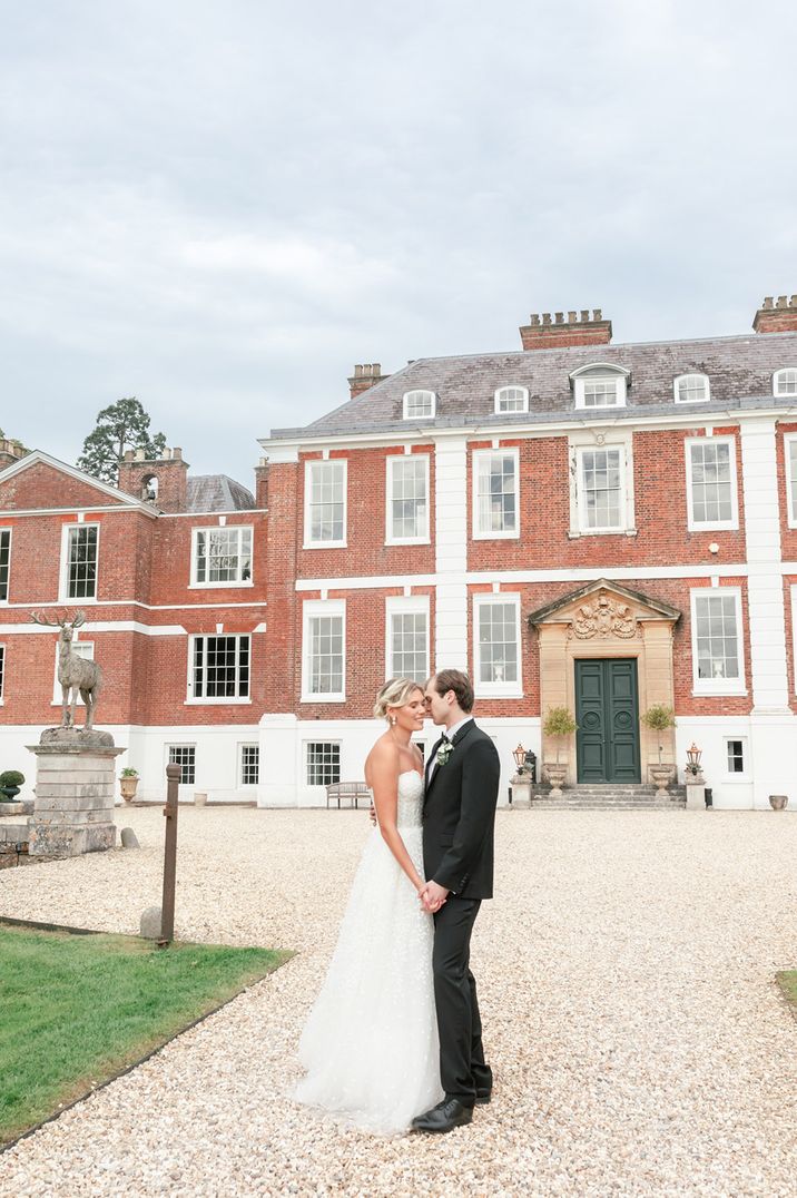 The bride and groom outside of Pynes House country house wedding venue 