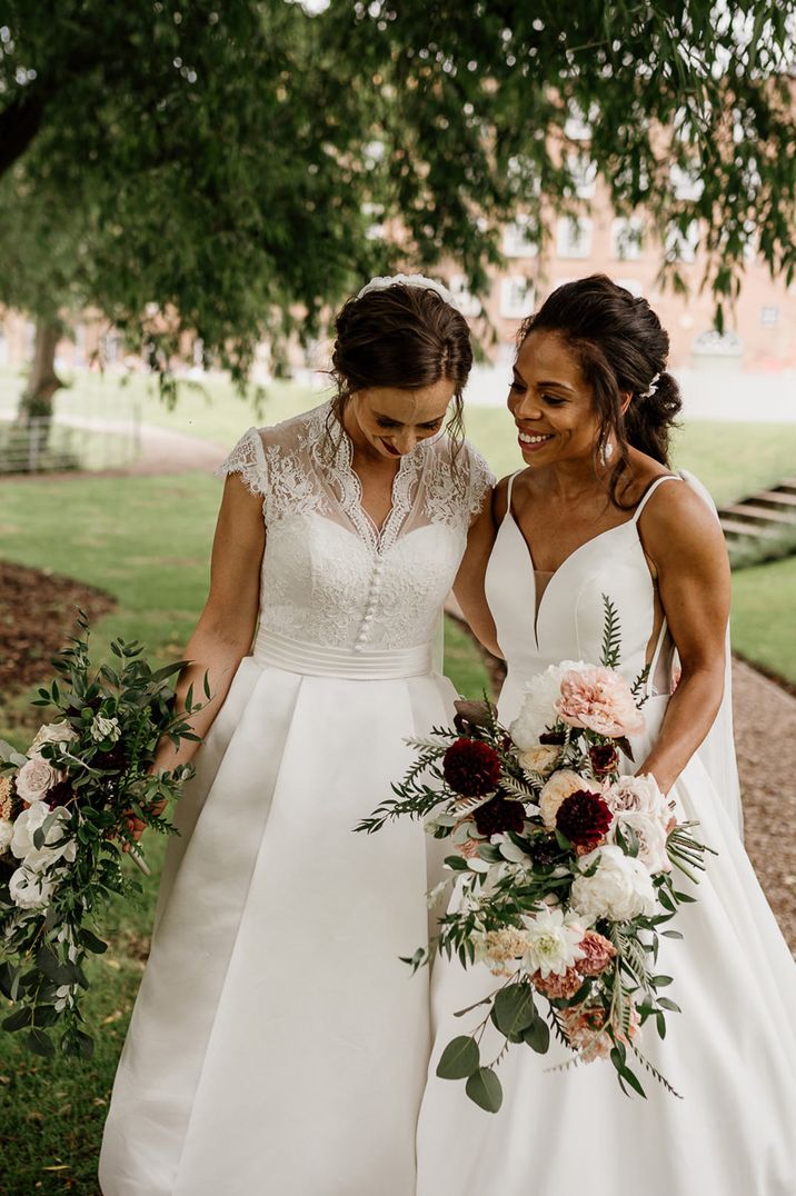 Two brides holding oversized wedding bouquets at West Mill Derby wedding 