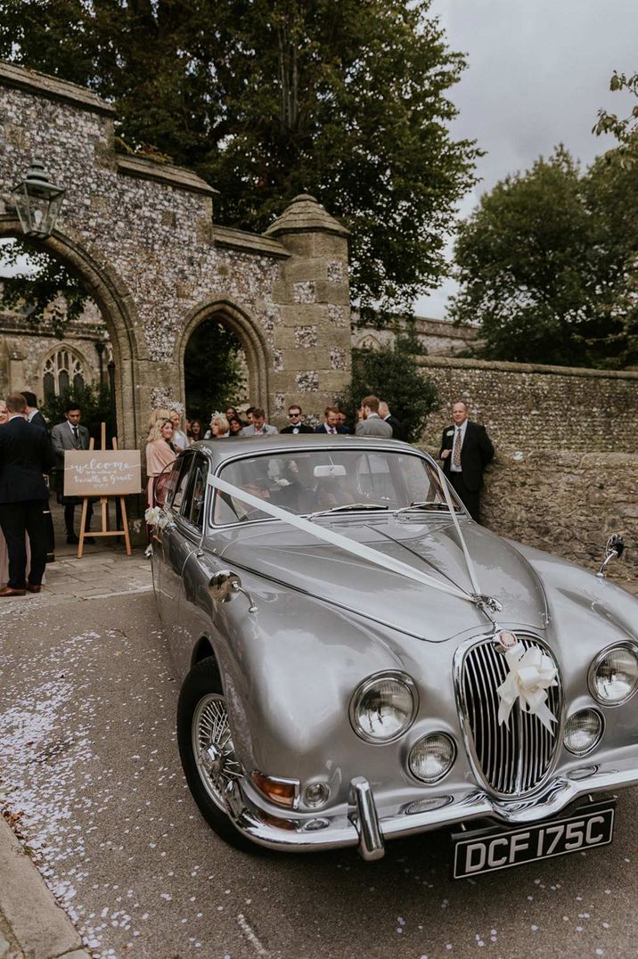 Vintage silver wedding car with white ribbon and bow