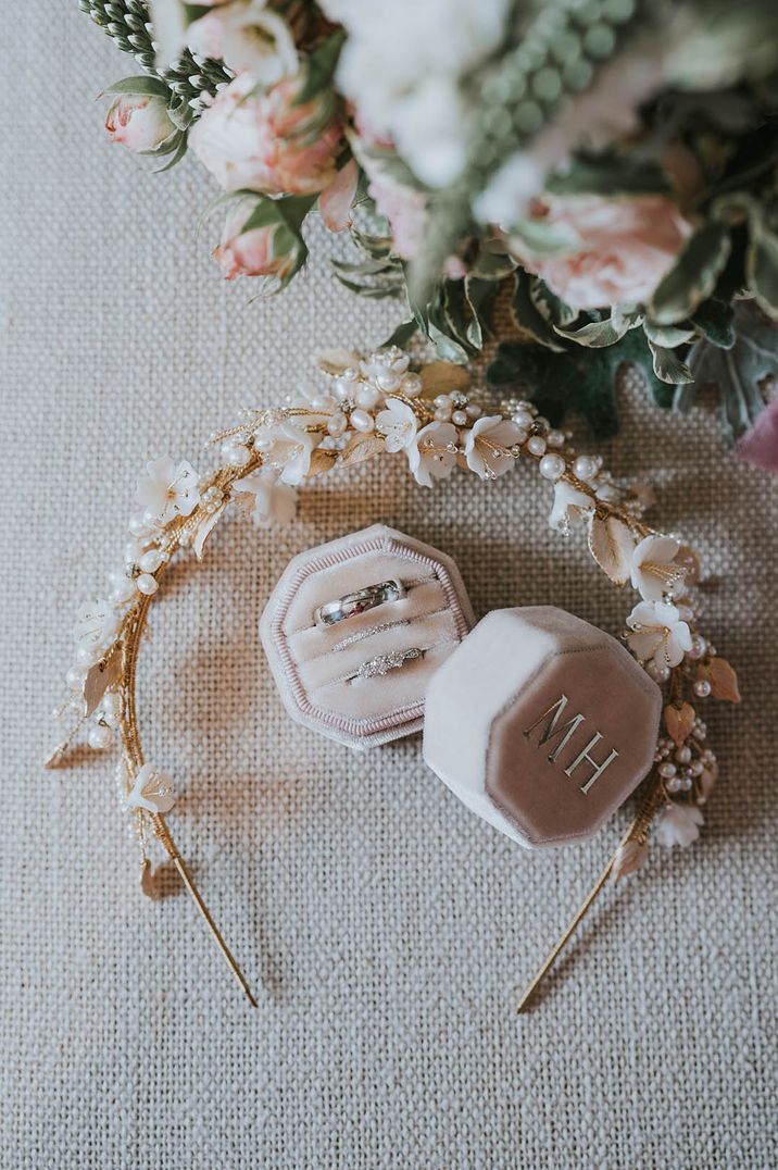 Pale pink velvet ring box with the bride and groom's wedding rings and the bride's engagement ring 