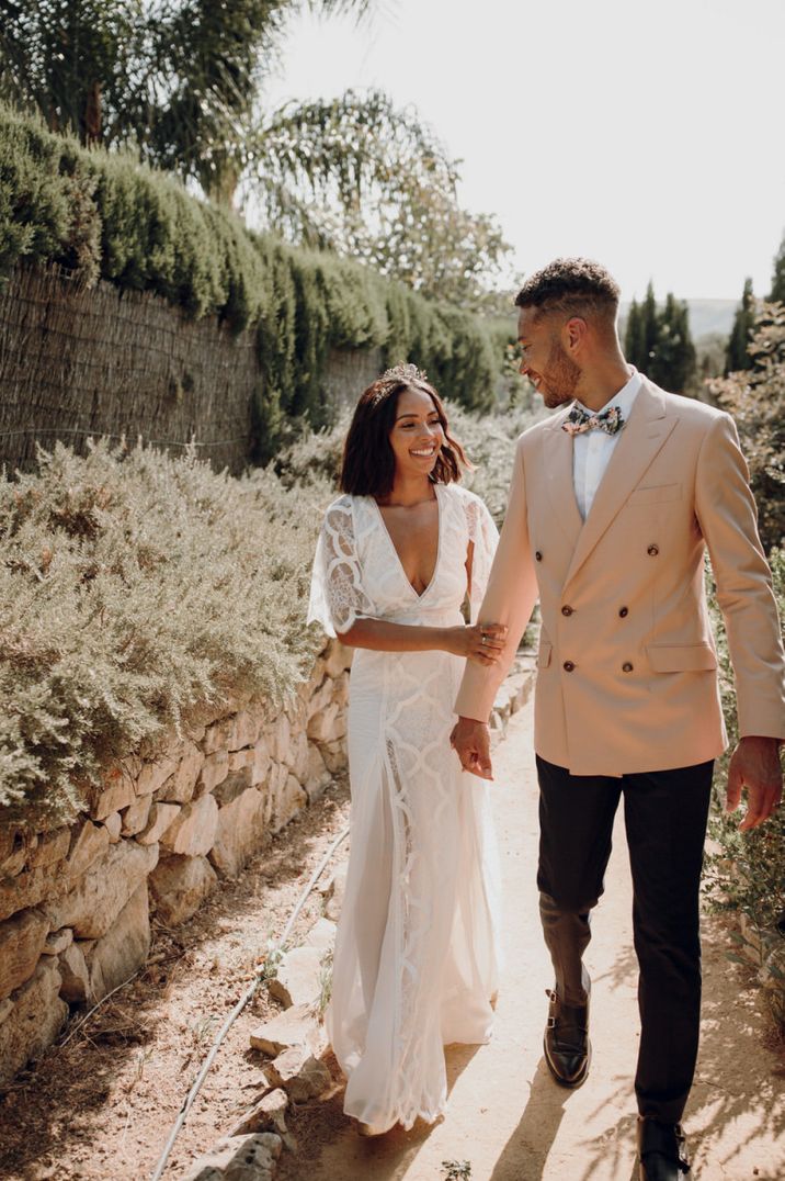 Bride in a Grace Loves Lace boho wedding dress and groom in a pink double breasted jacket at Spanish destination wedding 