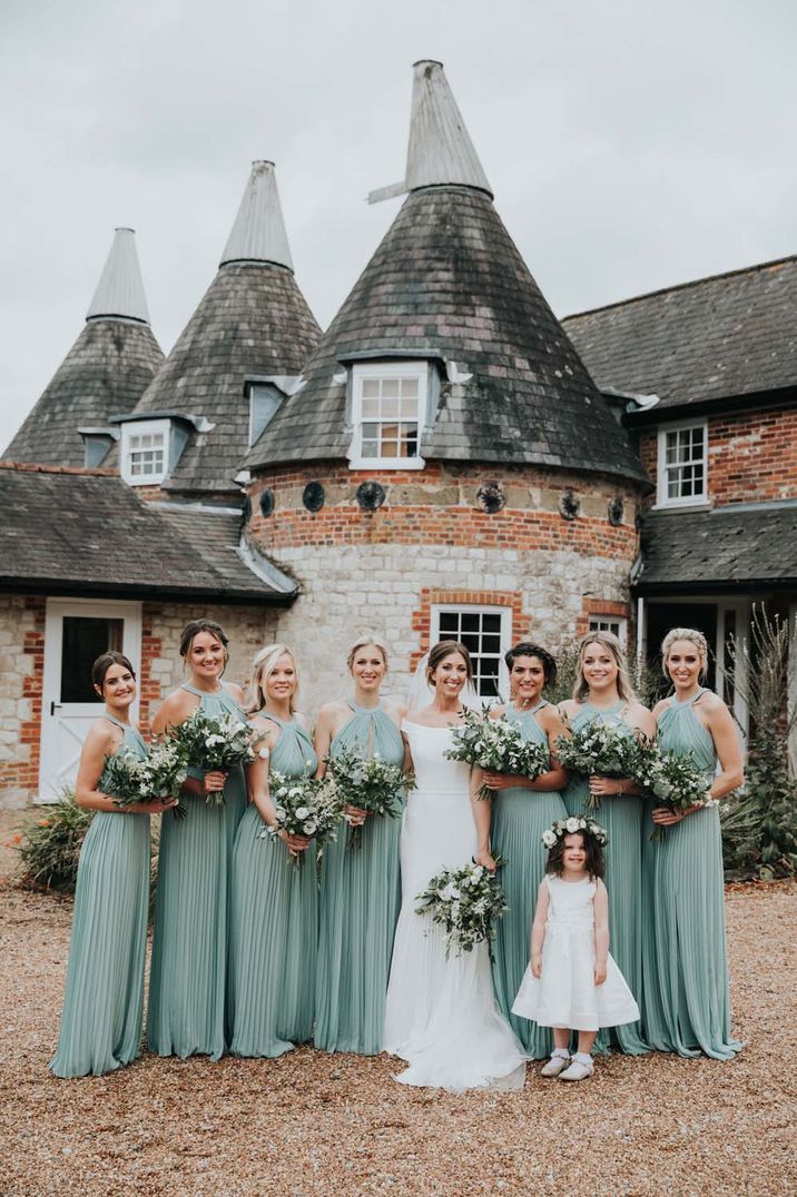 Bridesmaids in halter neck cutout mint green pleated bridesmaid dresses with bride in off the shoulder wedding dress 