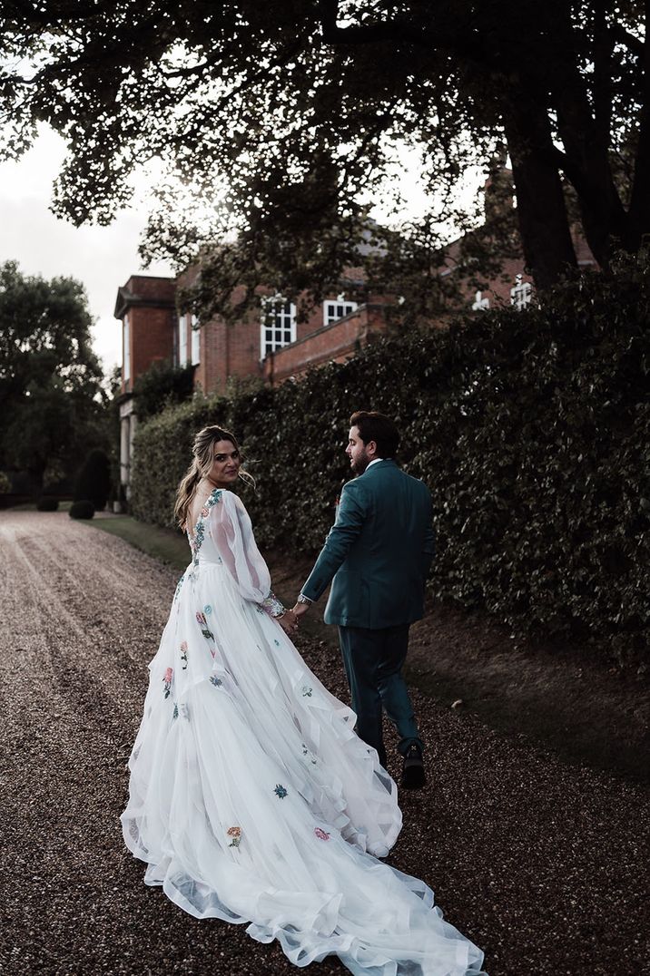 Custom Victoria Sanders wedding dress worn by the bride with the groom in a blue suit 