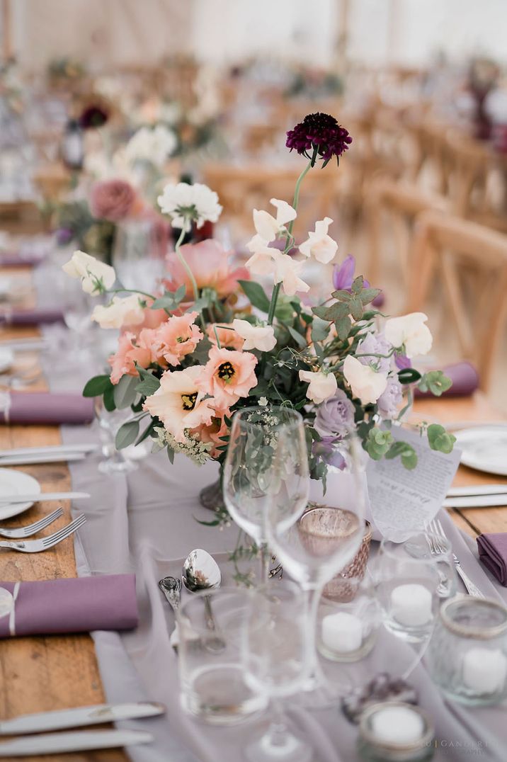 Purple wedding tablescape for 60k wedding with purple table runners, napkins and flower arrangements 