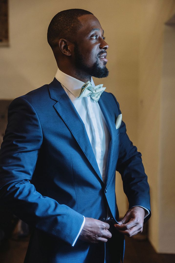 Groom in baby blue bowtie and dark blue suit