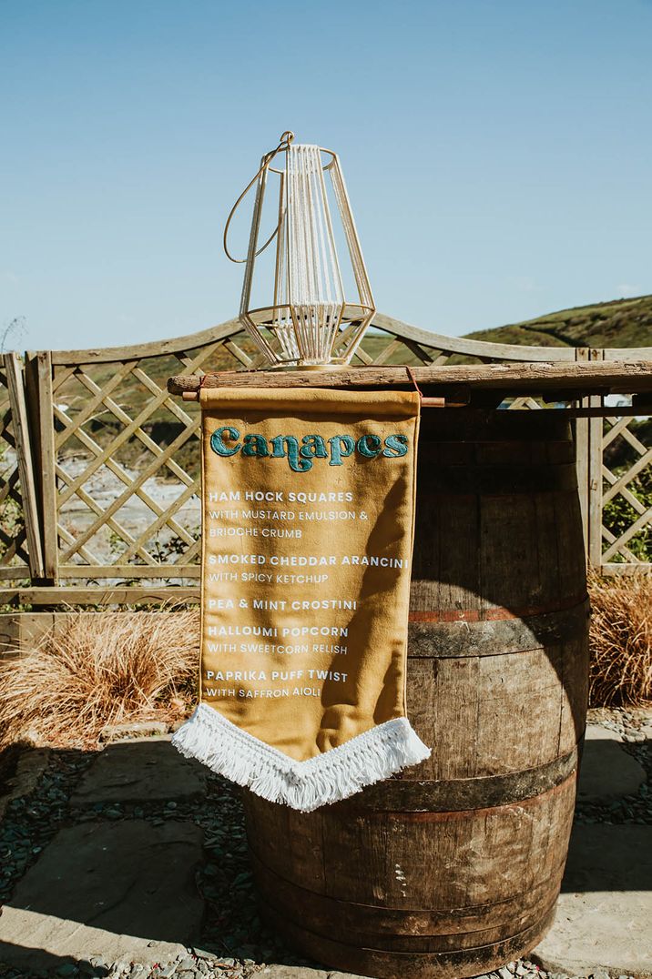 Mustard yellow fabric canapé menu sign for beach wedding 