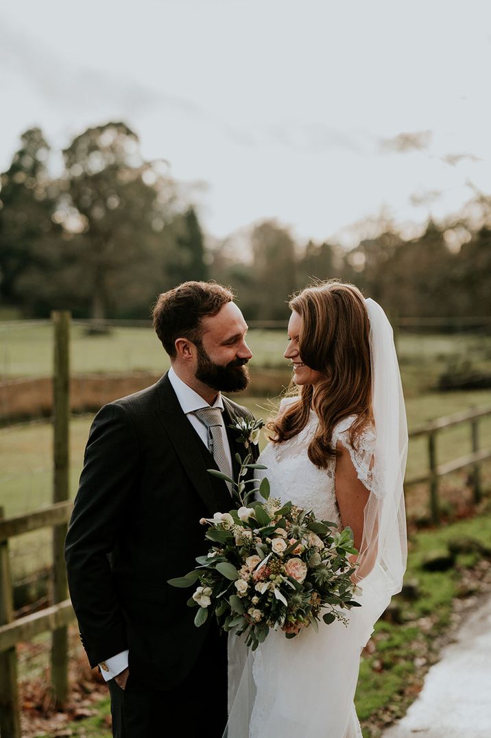 Bride and groom smile as they look into each other's eyes