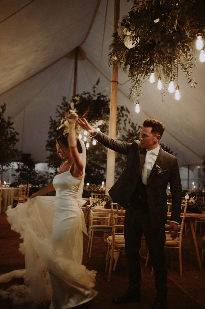 Weddings over 60k roundup featuring this castle wedding with the groom twirling the bride at their marquee reception 