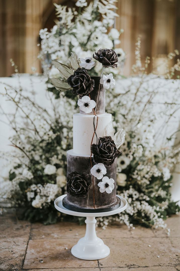 Black and white wedding cake for monochrome style wedding with white anemones and black roses 