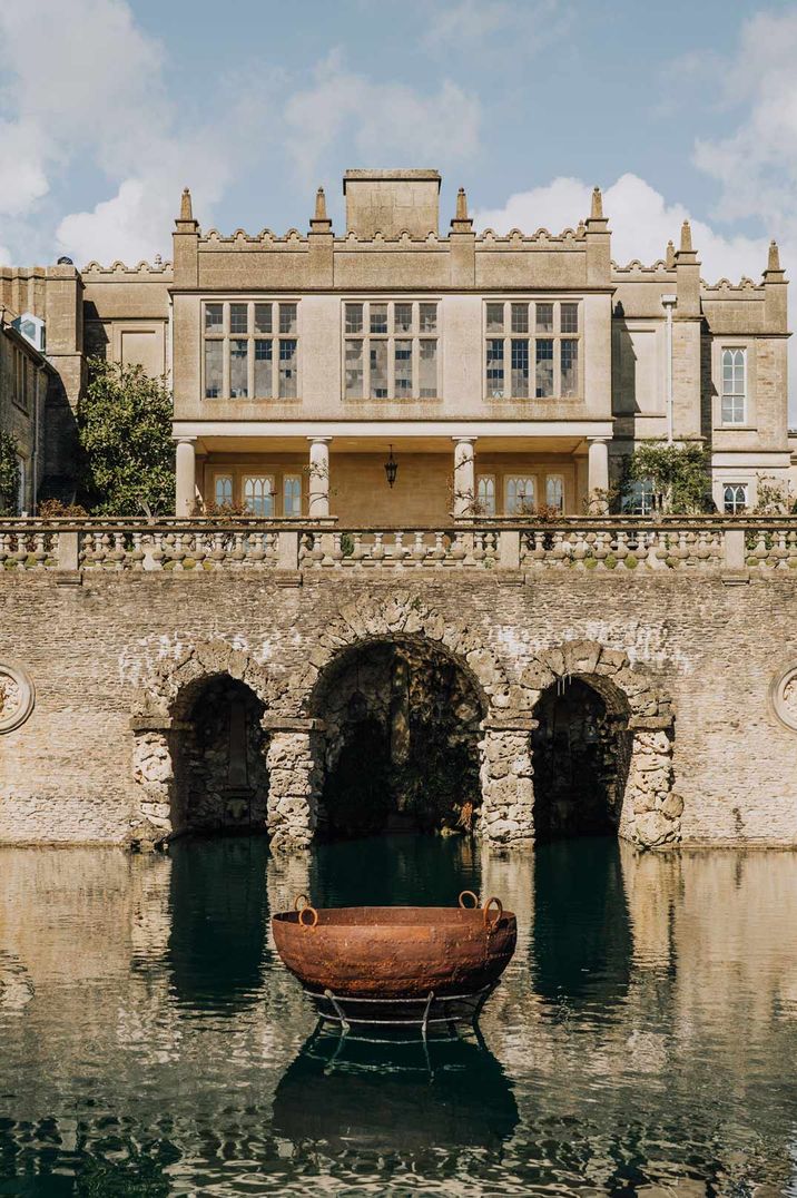 Exterior shot of Euridge Manor wedding venue with stone bridge, water feature and fountain - last minute wedding preparations 