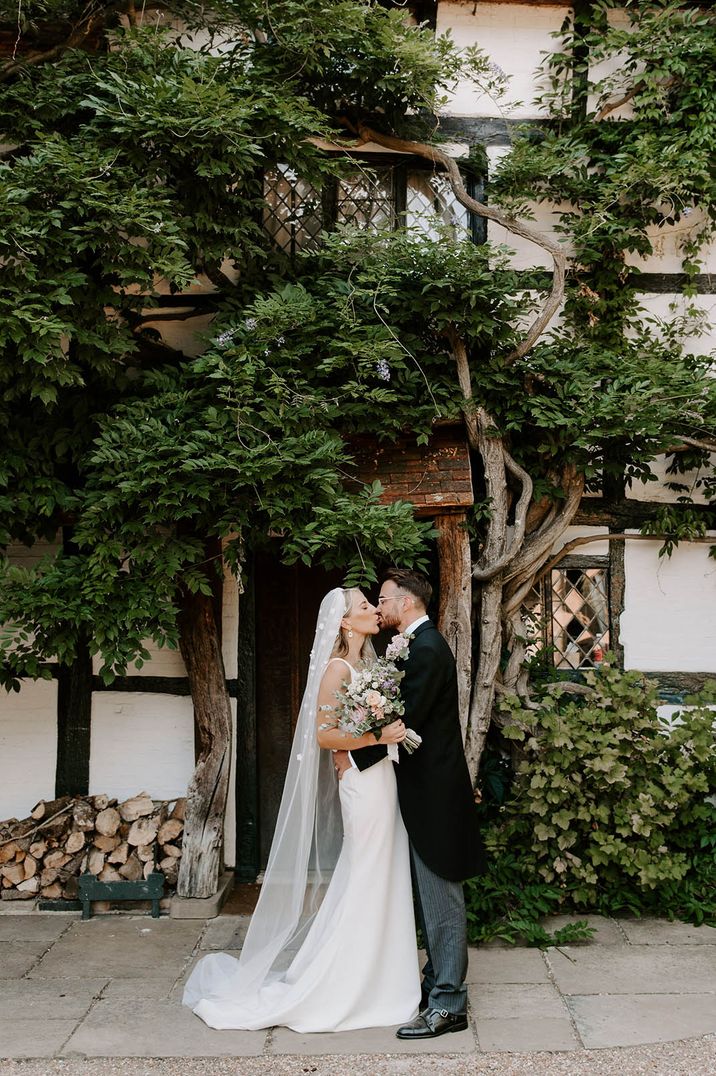 The bride and groom share a kiss at Ridge Farm wedding venue in Surrey 