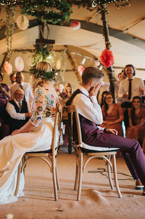 Couple sitting back to back as they play a Mr and Mrs game for wedding entertainment 