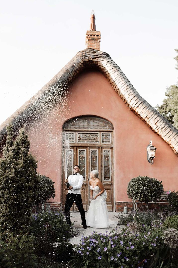 Bride and groom celebrating with a champagne spray photo shoot at Le Petit Chateau