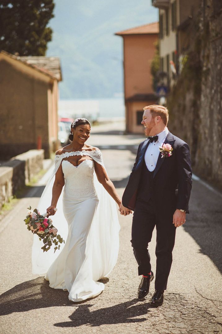 Lake Como wedding over 60k with the bride wearing a fun bridal cape and groom in back tuxedo 