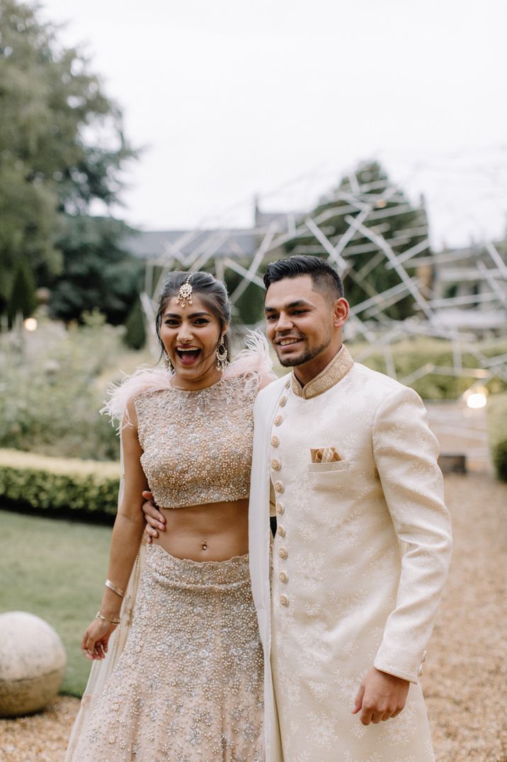 Indian bride and groom in gold outfits at luxury Aynhoe Park three-day wedding 