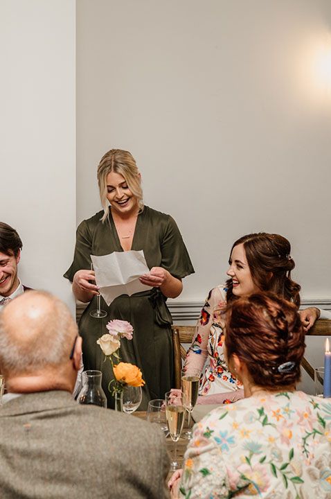 Maid of honour in khaki green short sleeve dress giving speech