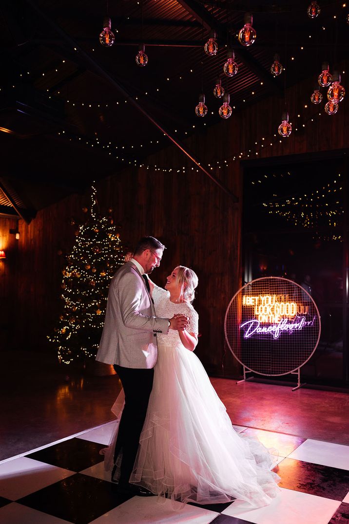 Bride in tulle bridal skirt dancing with the groom on the dance floor 