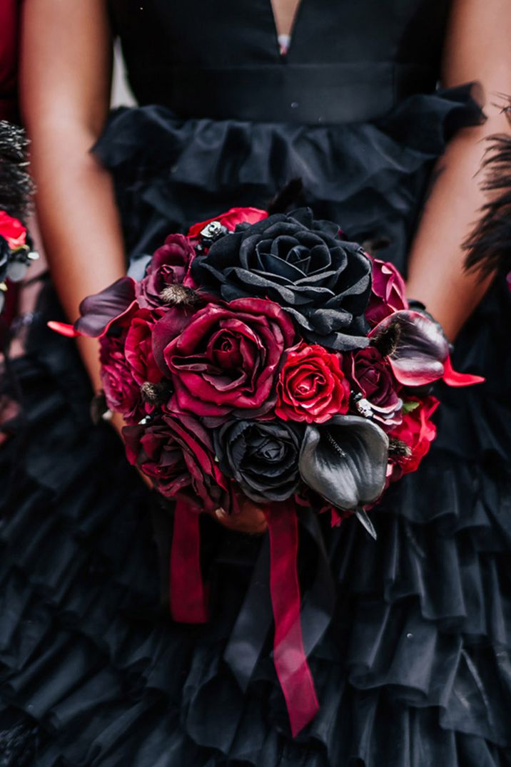 Deep red and black gothic wedding bouquet inspired by May birth flowers with roses and lilies 