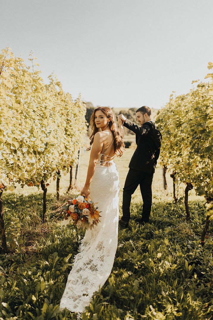 Bride in backless cowl neck wedding dress with groom at Brickhouse Vineyard wedding venue 